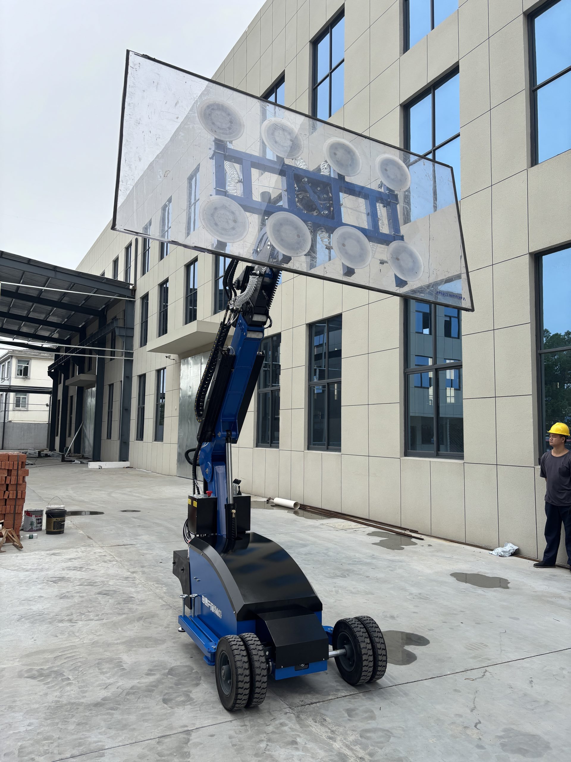 Olift GL800 electric vacuum lifter lifting a large glass panel at a customer delivery site