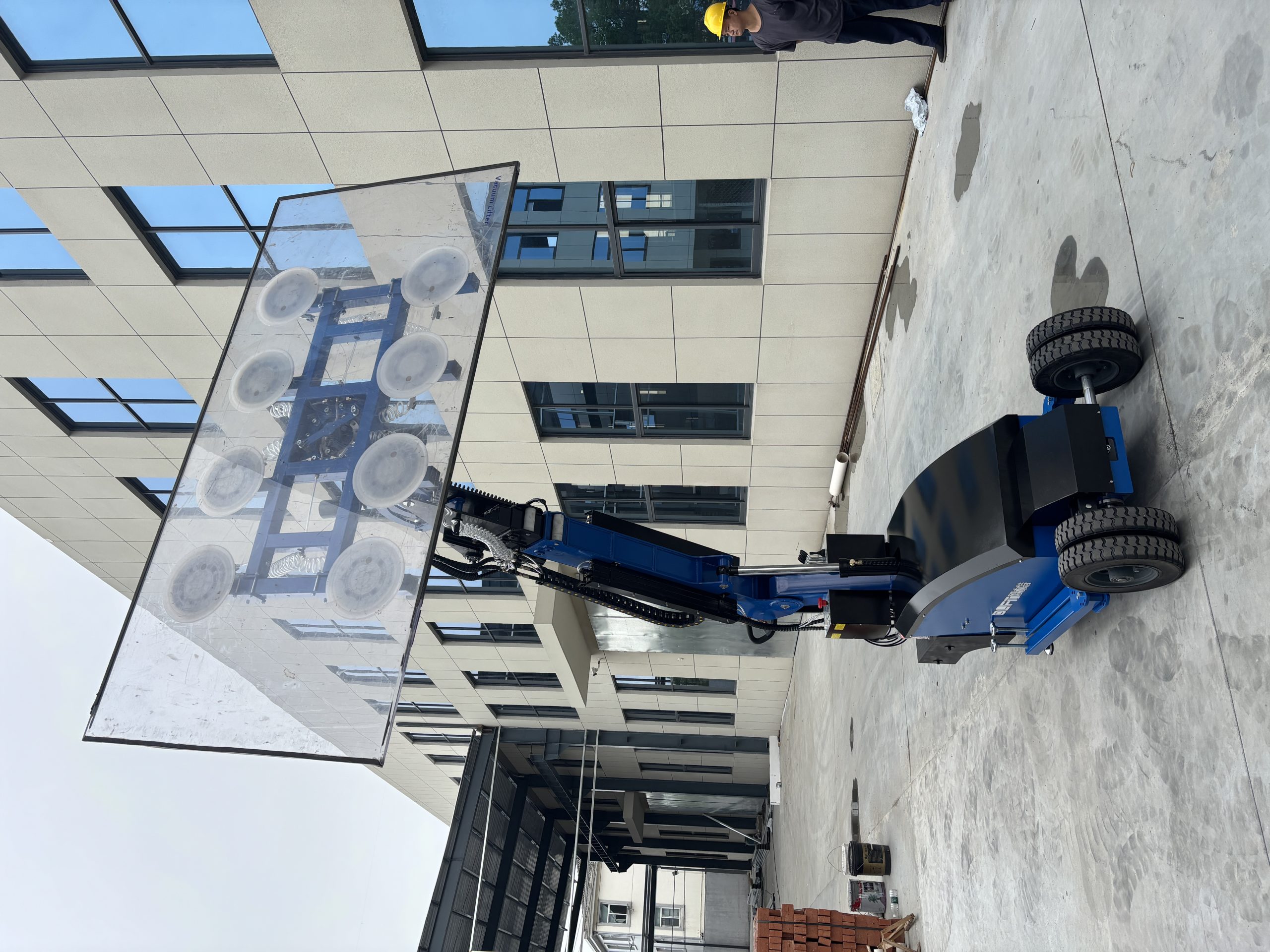 Olift GL800 electric vacuum lifter lifting a large glass panel at a customer delivery site